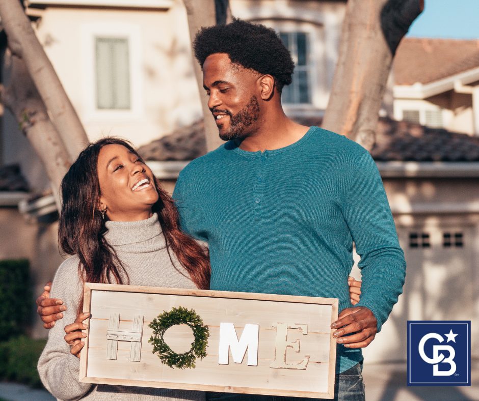 A happy couple carrying moving boxes into their first home, celebrating the excitement of affordable homeownership.