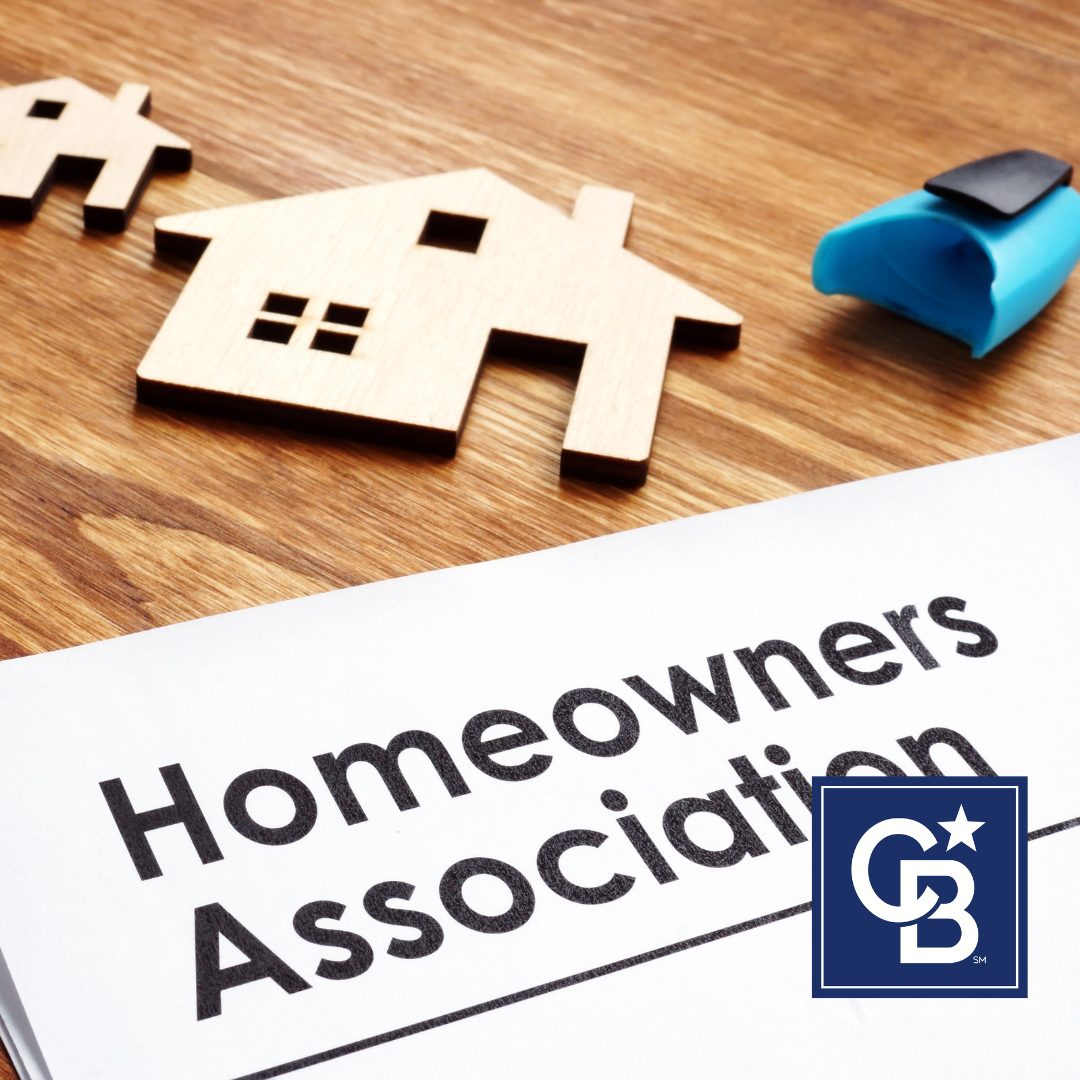 A stack of homeowners association documents, including bylaws and monthly fee statements, laid out neatly on a wooden table.