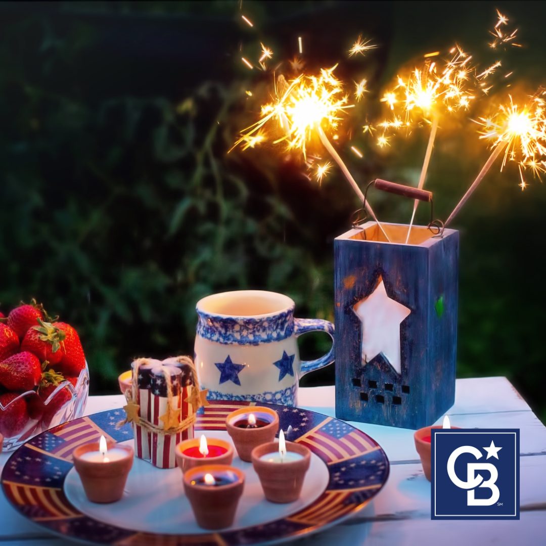 Festive Fourth of July home party table setting with red, white, and blue decorations, patriotic tableware, and seasonal flowers.