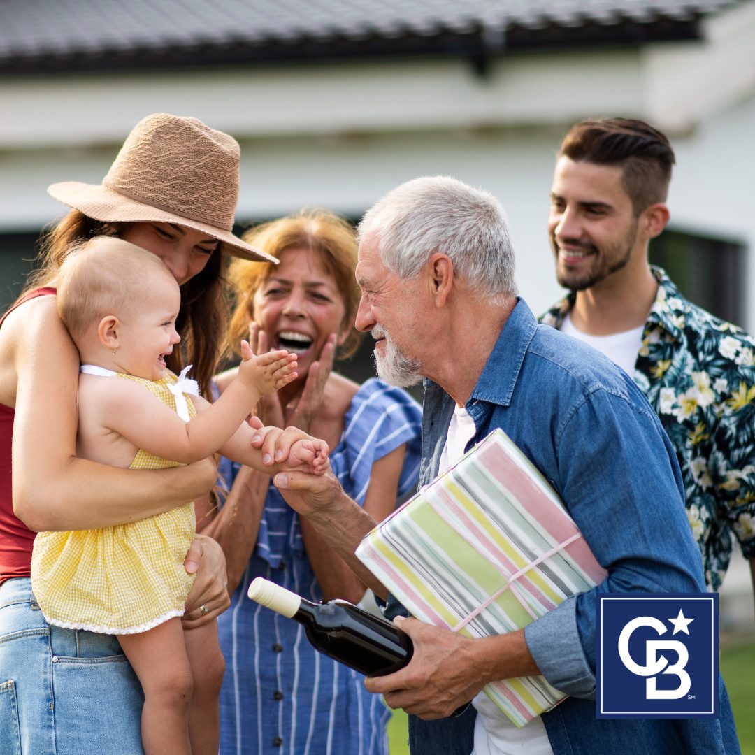 Multi-generational family celebrating in the backyard of their shared home, symbolizing the benefits of buying a multi-generational home.