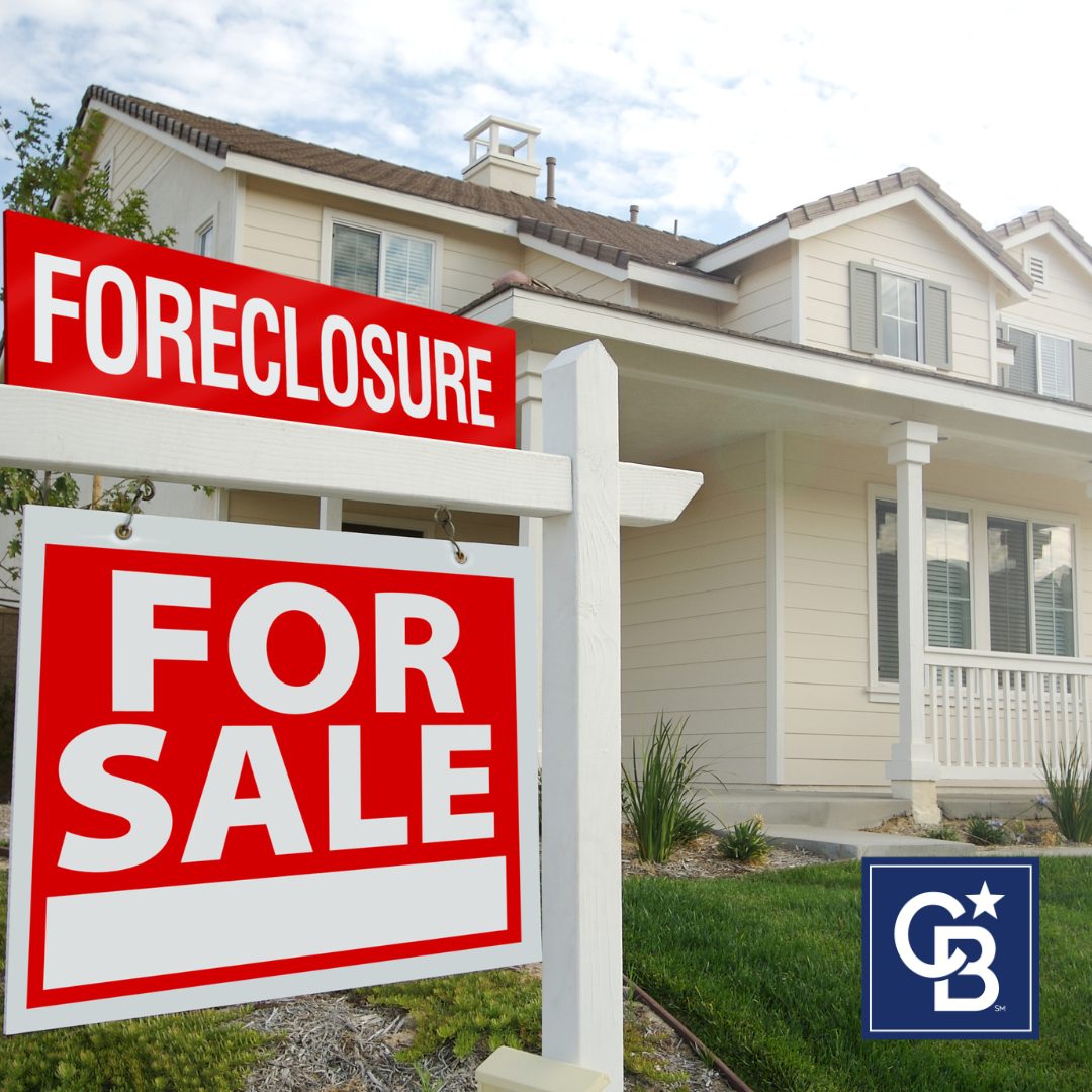 A residential front yard featuring a real estate "For Sale" sign with a "Foreclosure" label above it, symbolizing the topic of foreclosure in the housing market.